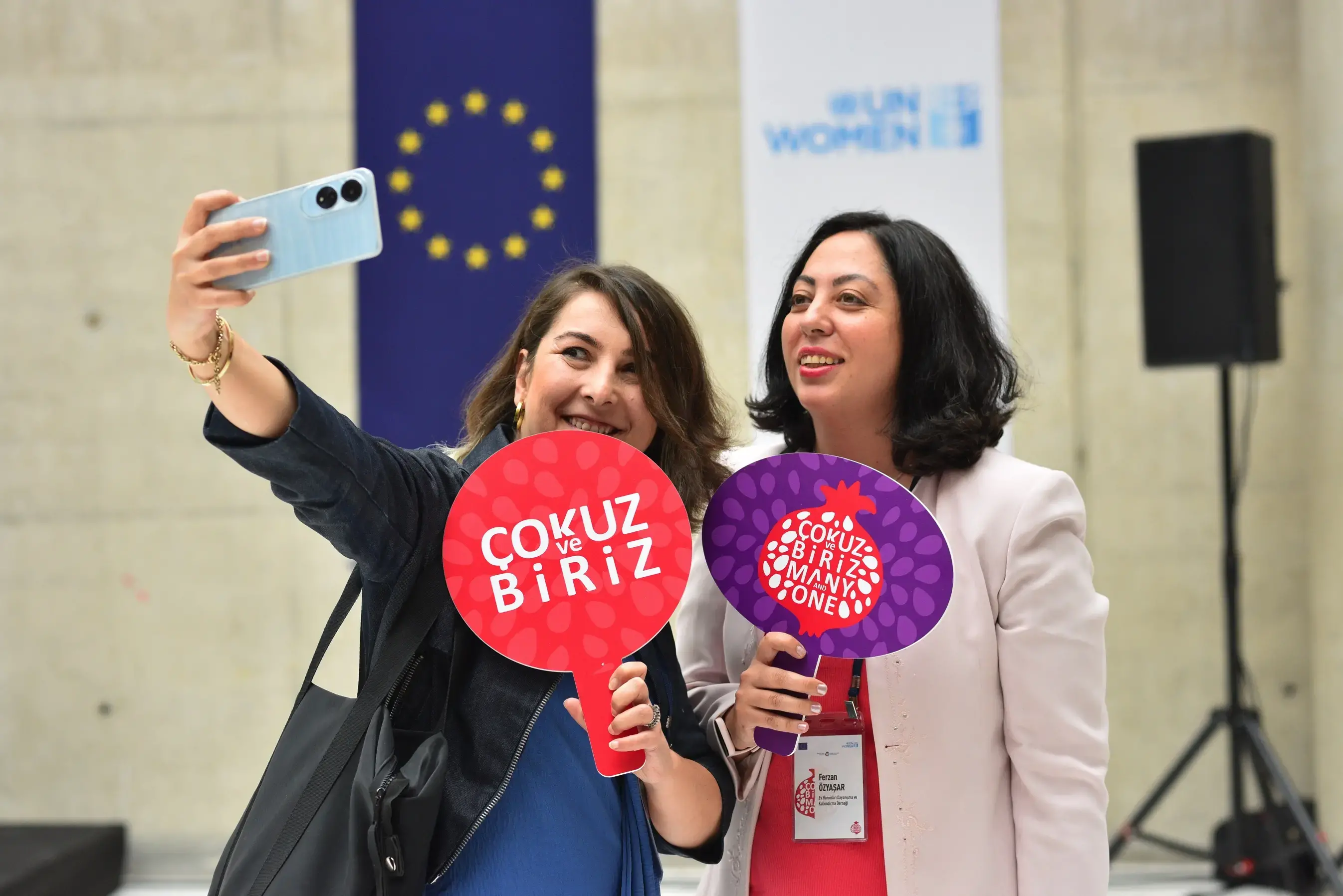 Representatives of civil society in Türkiye are posing while holding “We are Many and One” signs. Photo: UN Women