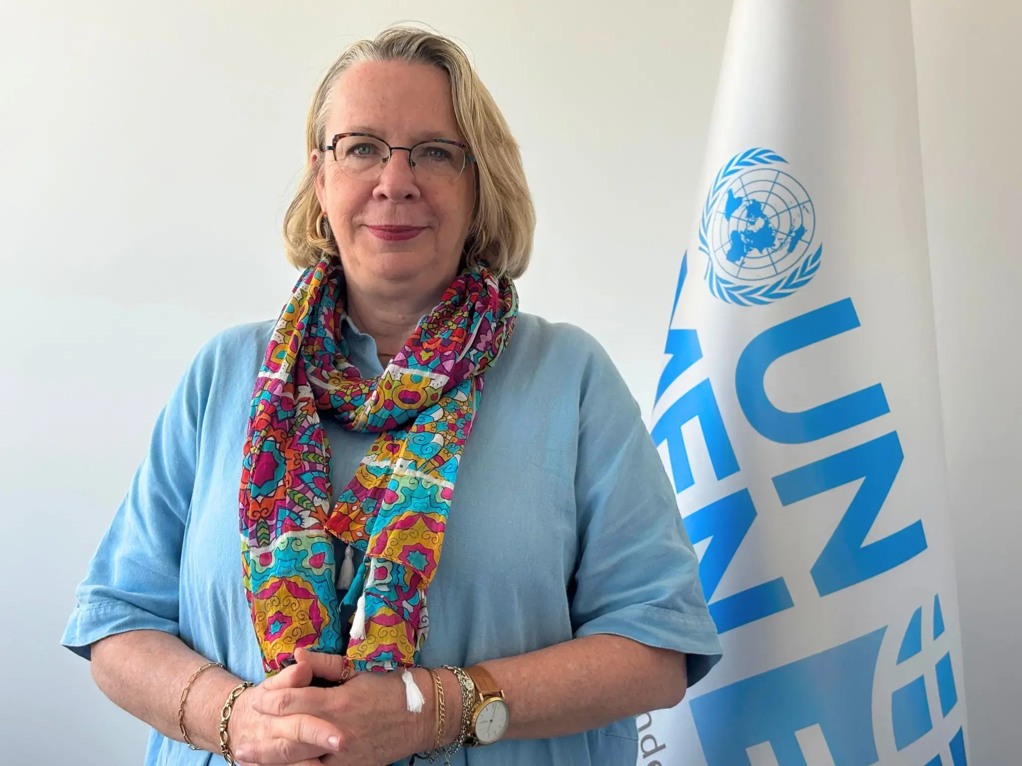 A profile picture of Maryse Guimond with UN Women flag in the background